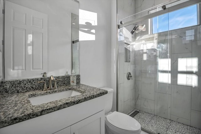 bathroom featuring a stall shower, vanity, and toilet