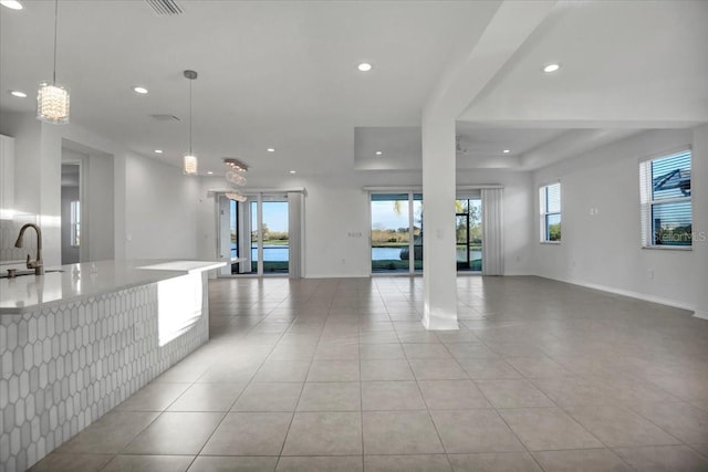 interior space with light tile patterned floors, baseboards, a wealth of natural light, and recessed lighting