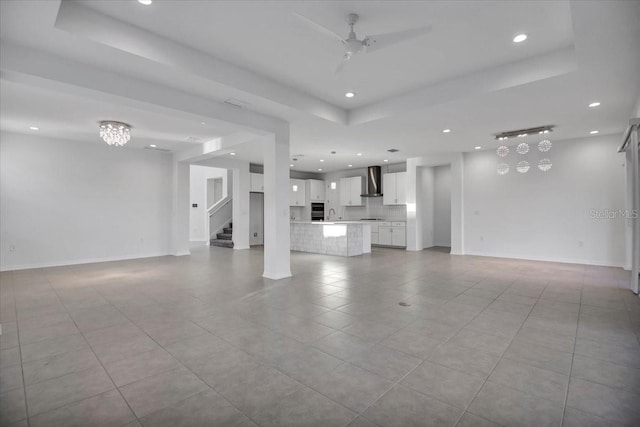 unfurnished living room with a raised ceiling and recessed lighting