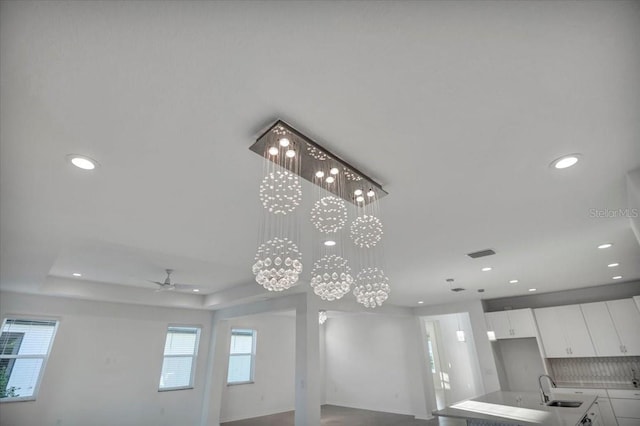 room details featuring recessed lighting, a sink, visible vents, and white cabinets