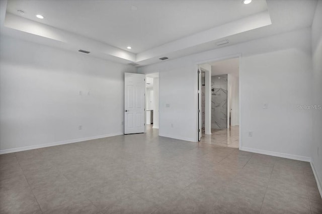 unfurnished room featuring baseboards, a tray ceiling, and recessed lighting