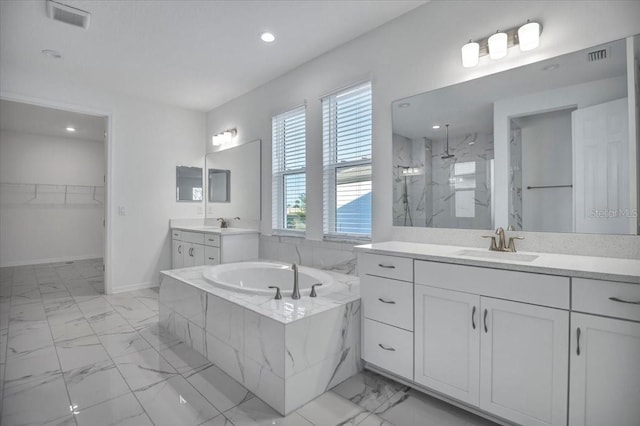 bathroom featuring a bath, marble finish floor, a sink, and a marble finish shower