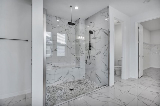 bathroom featuring marble finish floor, a marble finish shower, toilet, and baseboards