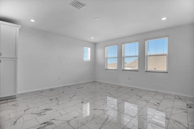 empty room featuring marble finish floor, baseboards, visible vents, and recessed lighting