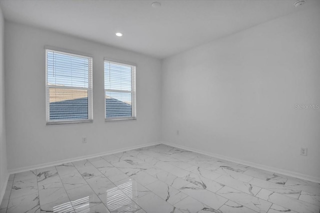 unfurnished room featuring marble finish floor, recessed lighting, and baseboards