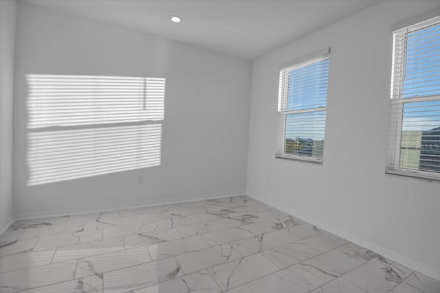 spare room featuring baseboards, marble finish floor, recessed lighting, and a healthy amount of sunlight