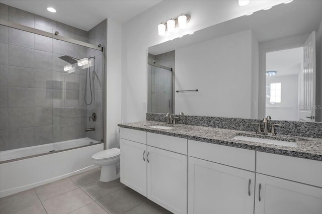 full bath with enclosed tub / shower combo, tile patterned flooring, a sink, and toilet