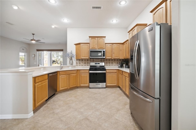 kitchen with stainless steel appliances, light countertops, visible vents, backsplash, and a peninsula