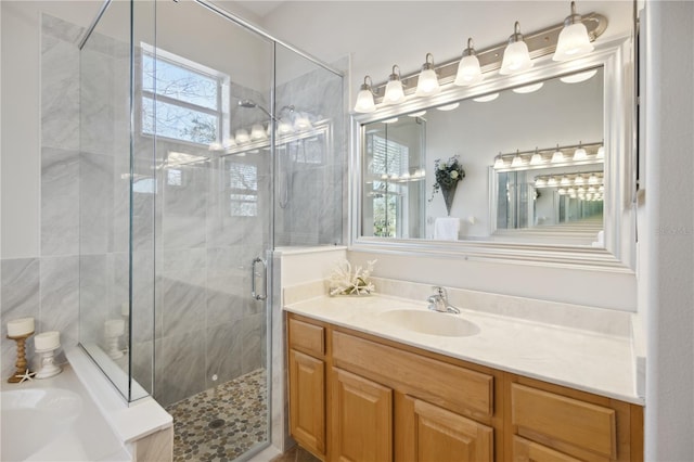 bathroom with a stall shower, a bath, and vanity