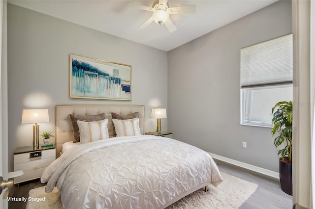 bedroom featuring a ceiling fan, baseboards, and wood finished floors