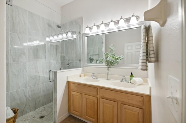 full bathroom featuring double vanity, a stall shower, and a sink