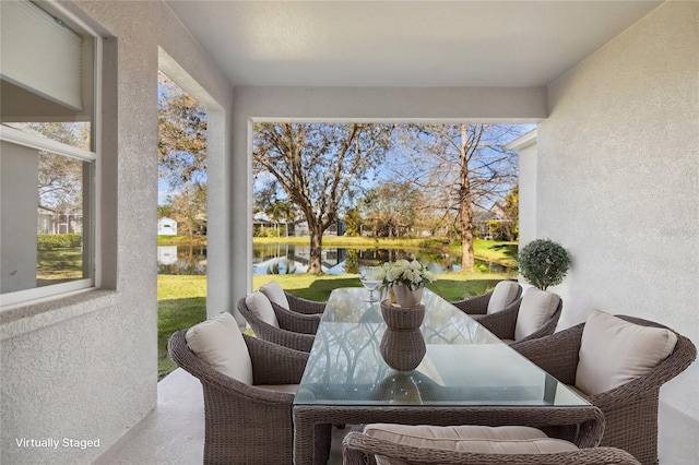 sunroom / solarium featuring a water view