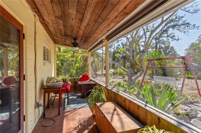 sunroom with a healthy amount of sunlight, wooden ceiling, and ceiling fan