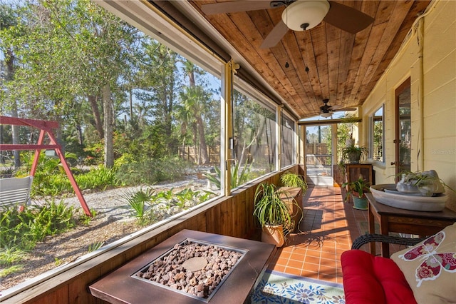 sunroom with wooden ceiling, a ceiling fan, and a wealth of natural light