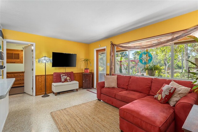 living area with a wainscoted wall and speckled floor