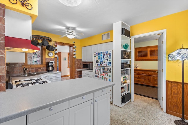 kitchen with visible vents, white cabinets, ceiling fan, stainless steel microwave, and a sink