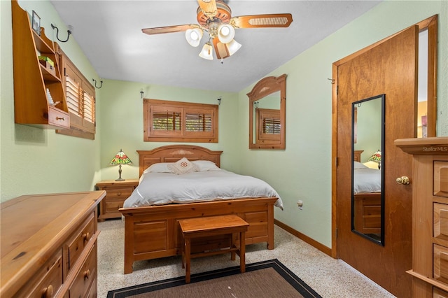 bedroom with a ceiling fan and baseboards