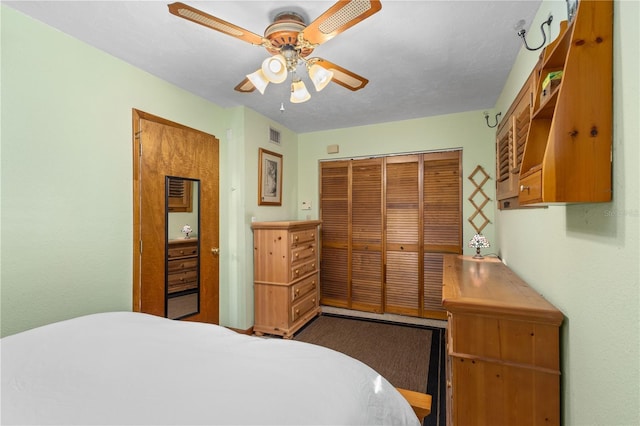 bedroom with ceiling fan, visible vents, and a closet