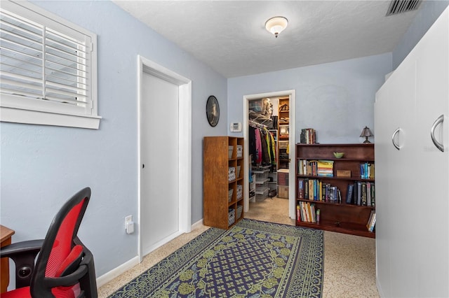 office space featuring baseboards, visible vents, and a textured ceiling