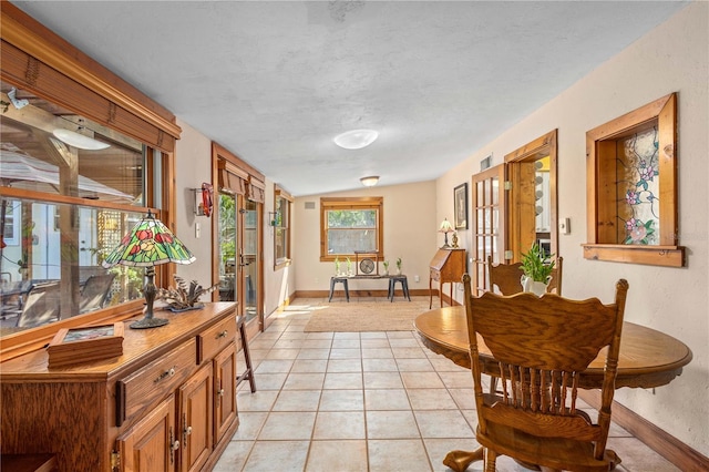 interior space featuring light tile patterned flooring, vaulted ceiling, and baseboards