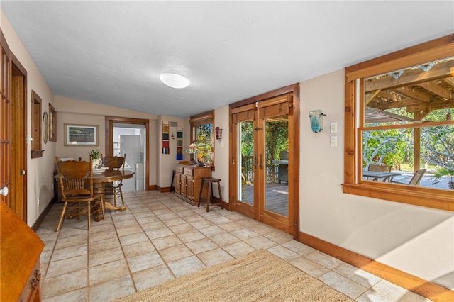 interior space with lofted ceiling, french doors, and baseboards