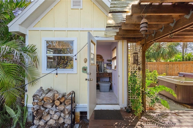 property entrance with a hot tub