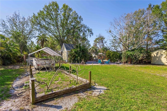 view of yard with an outbuilding, a garden, and a storage shed