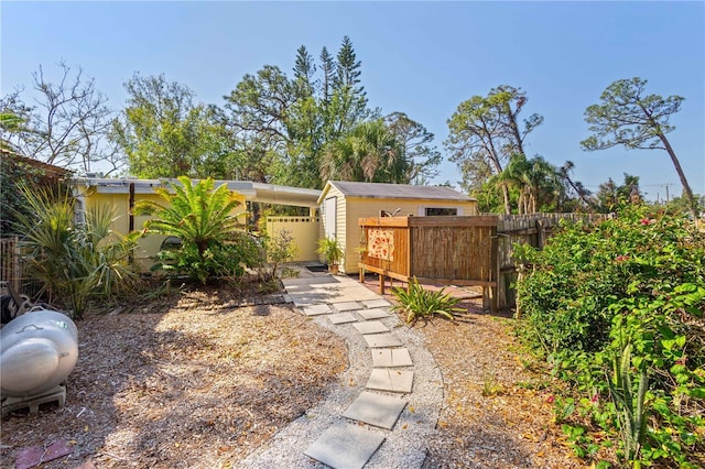 view of yard with an outbuilding, fence, and a storage unit