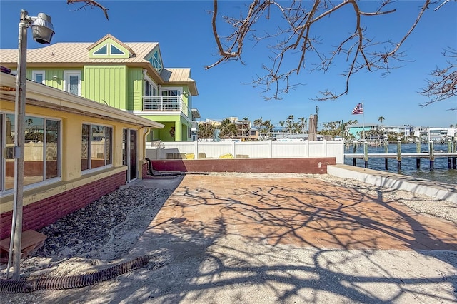 exterior space with a dock, a water view, and fence