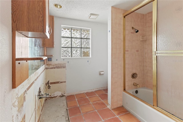 full bath with shower / bath combination with glass door and a textured ceiling