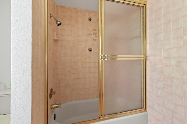 bathroom with shower / bath combination with glass door