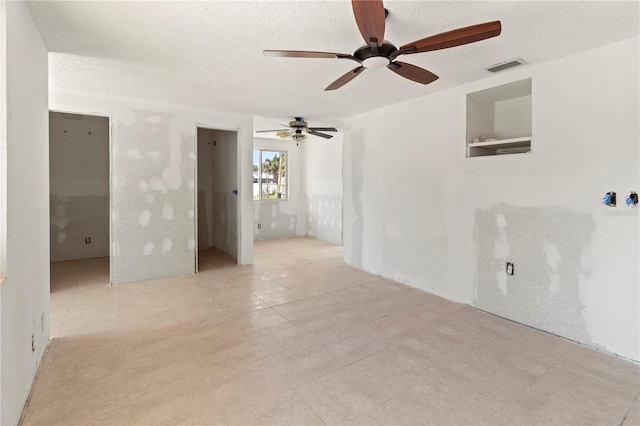 unfurnished room with visible vents and a textured ceiling