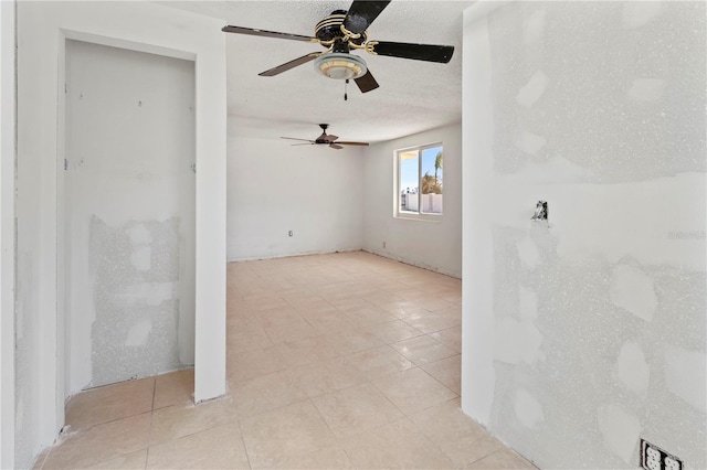 spare room featuring a textured ceiling and light tile patterned flooring