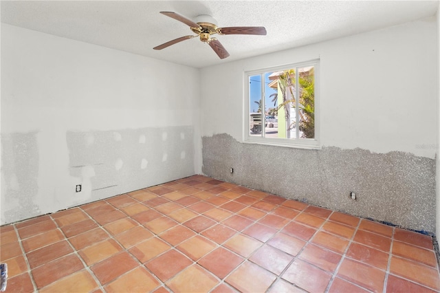 spare room with a textured ceiling and a ceiling fan