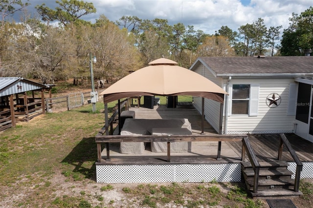 exterior space with fence, a wooden deck, and a gazebo