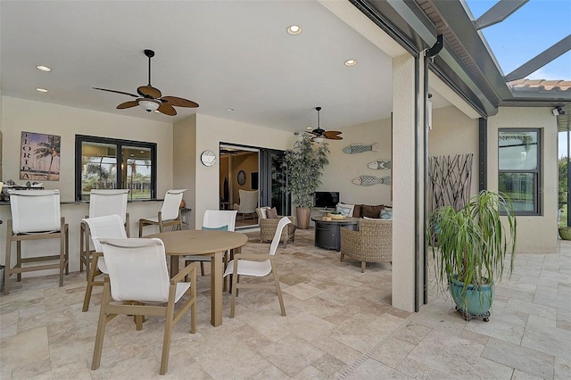 dining space with recessed lighting, stone tile floors, a skylight, and a ceiling fan