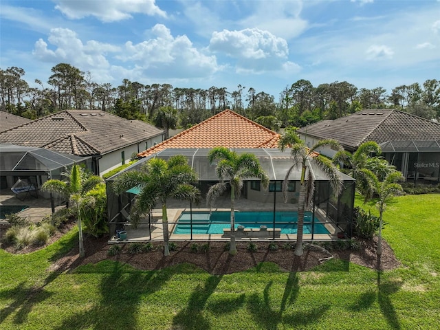 outdoor pool with glass enclosure, a patio, and a yard