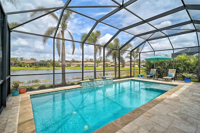 pool with glass enclosure, a patio, and a water view