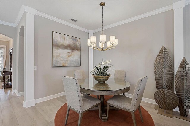 dining space with visible vents, arched walkways, ornamental molding, and light wood finished floors