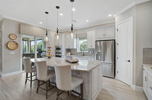 kitchen featuring a sink, stainless steel appliances, ornamental molding, and decorative backsplash