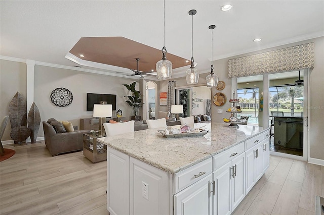 kitchen featuring light wood finished floors, crown molding, and ceiling fan