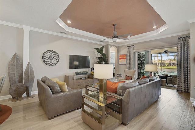 living area with visible vents, light wood-style flooring, and a raised ceiling