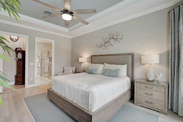 bedroom featuring visible vents, a tray ceiling, crown molding, light wood finished floors, and baseboards