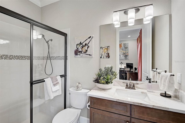 full bathroom with a shower stall, toilet, vanity, and a textured wall