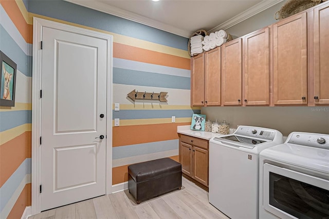 laundry area featuring baseboards, ornamental molding, washer and dryer, light wood-style floors, and cabinet space