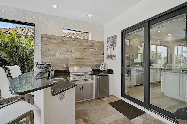 view of patio / terrace with an outdoor kitchen, grilling area, and a sink