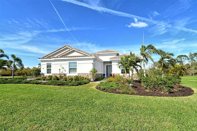 view of front facade featuring stucco siding, a tiled roof, stone siding, and a front yard