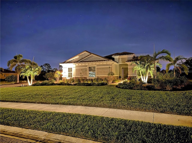 mediterranean / spanish-style house with a front lawn and stucco siding