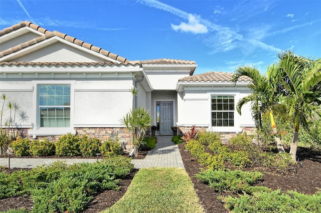 view of front of home featuring stone siding and stucco siding