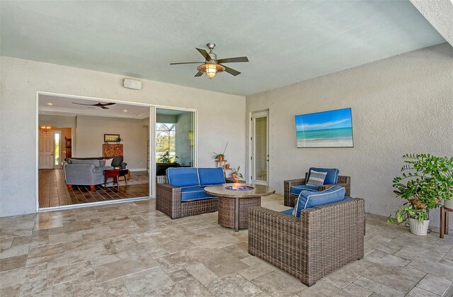 view of patio with a ceiling fan and an outdoor living space with a fire pit